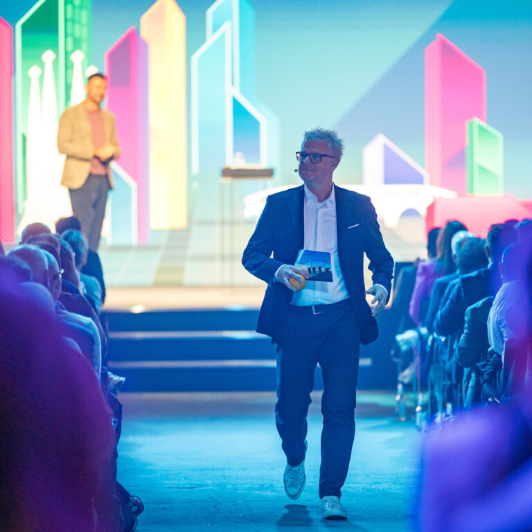 Holger Erdrich läuft als Moderator selbstbewusst durch das Publikum beim SAP Partner Summit 2025 in Berlin